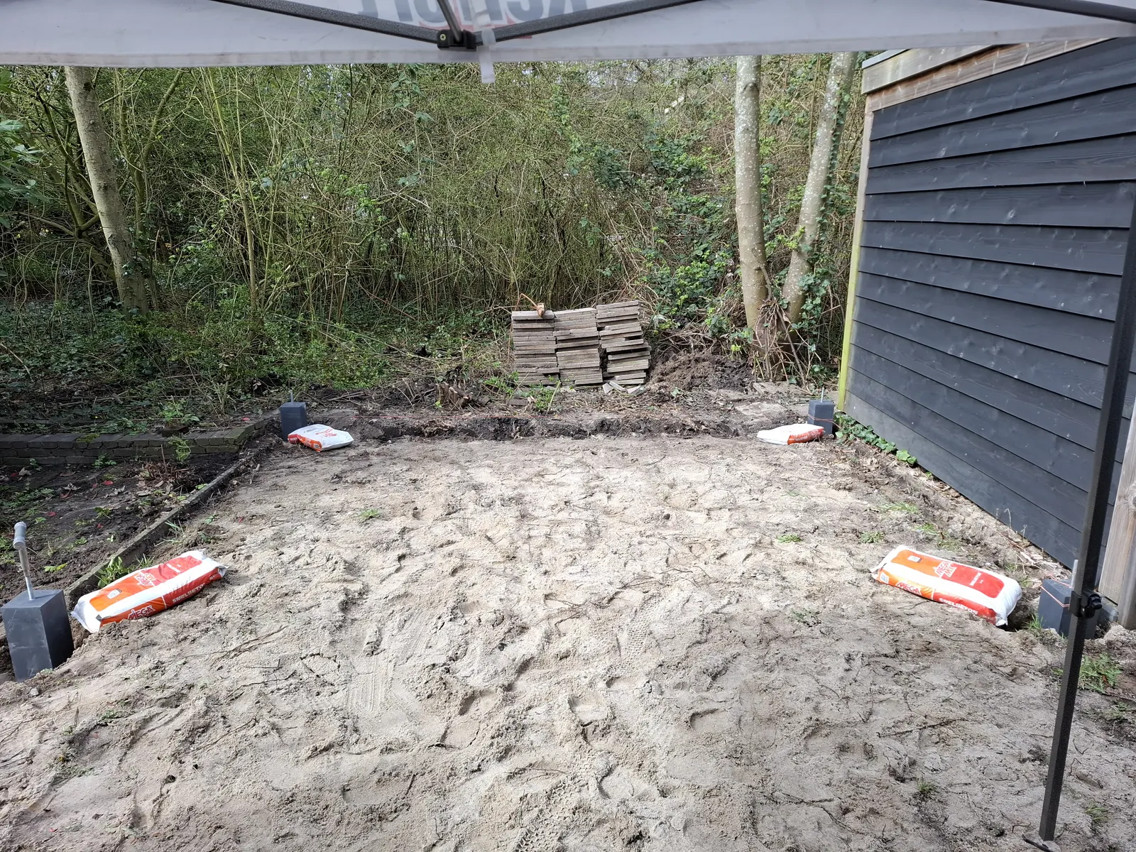 Uitgegraven en geëgaliseerde ondergrond aan het begin van de bouw van een overkapping