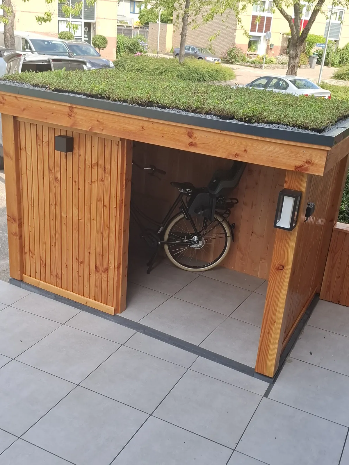 Houten fietsenberging met sedumdak en buitenlamp