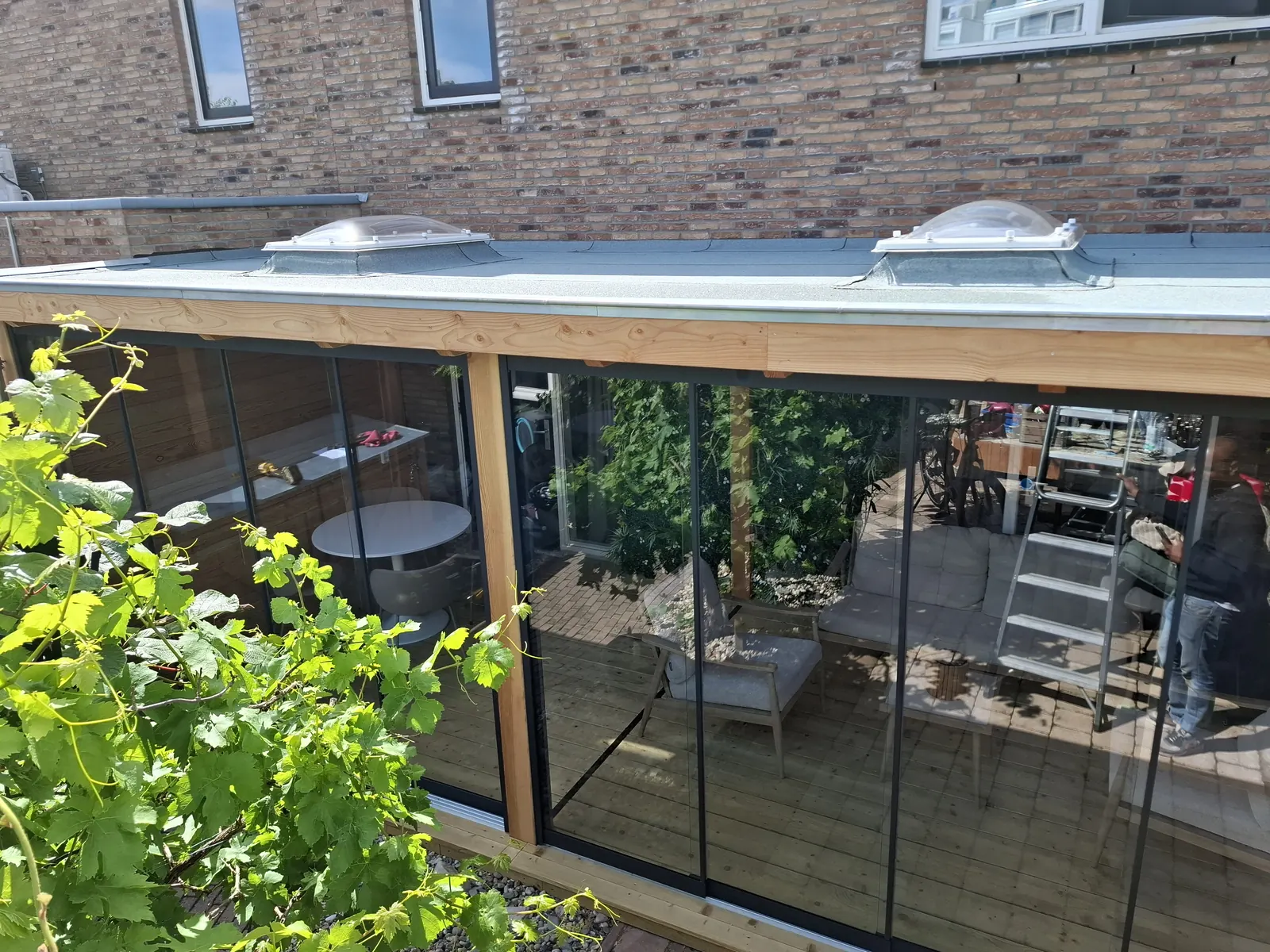 Overkapping aan de woning met lichtkoepels en glazen schuifwanden