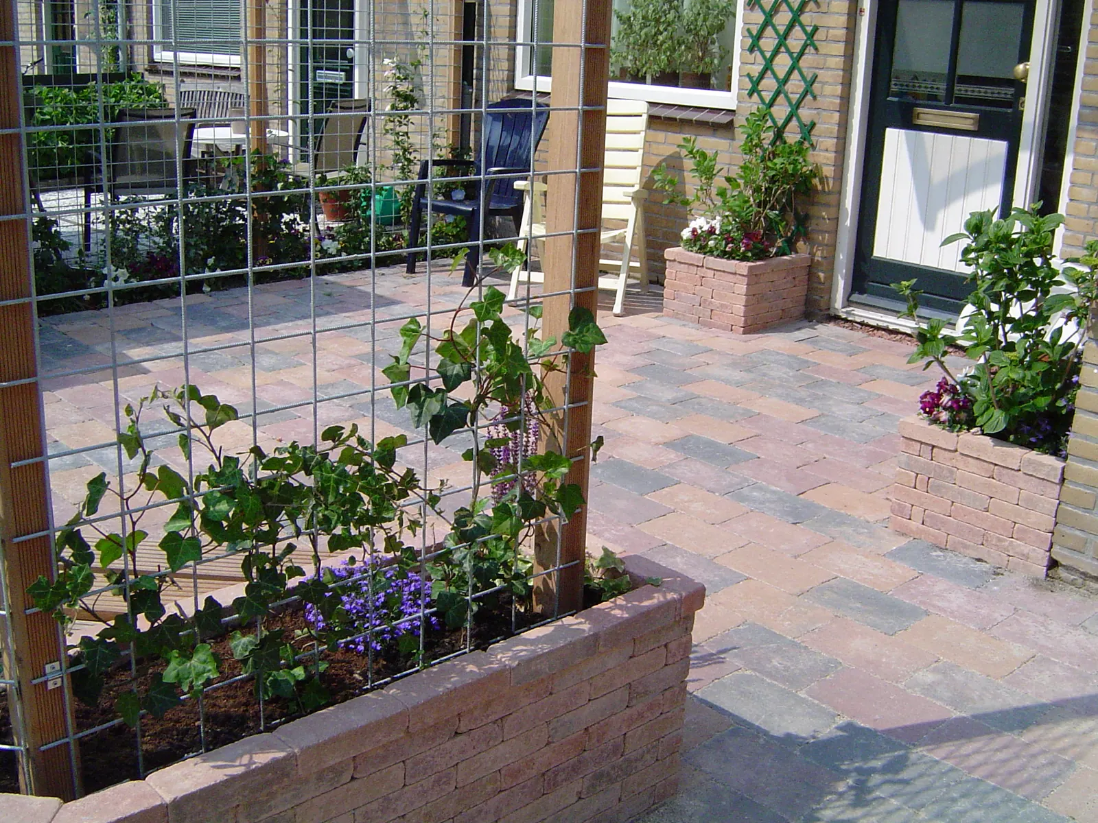 Gemetselde plantenbak met klimrek in een voortuin