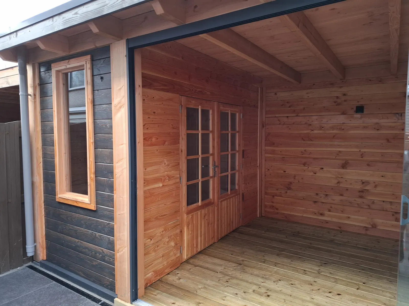Tuinhuis van zwart gebeitst hout met douglas binnenzijde en open front