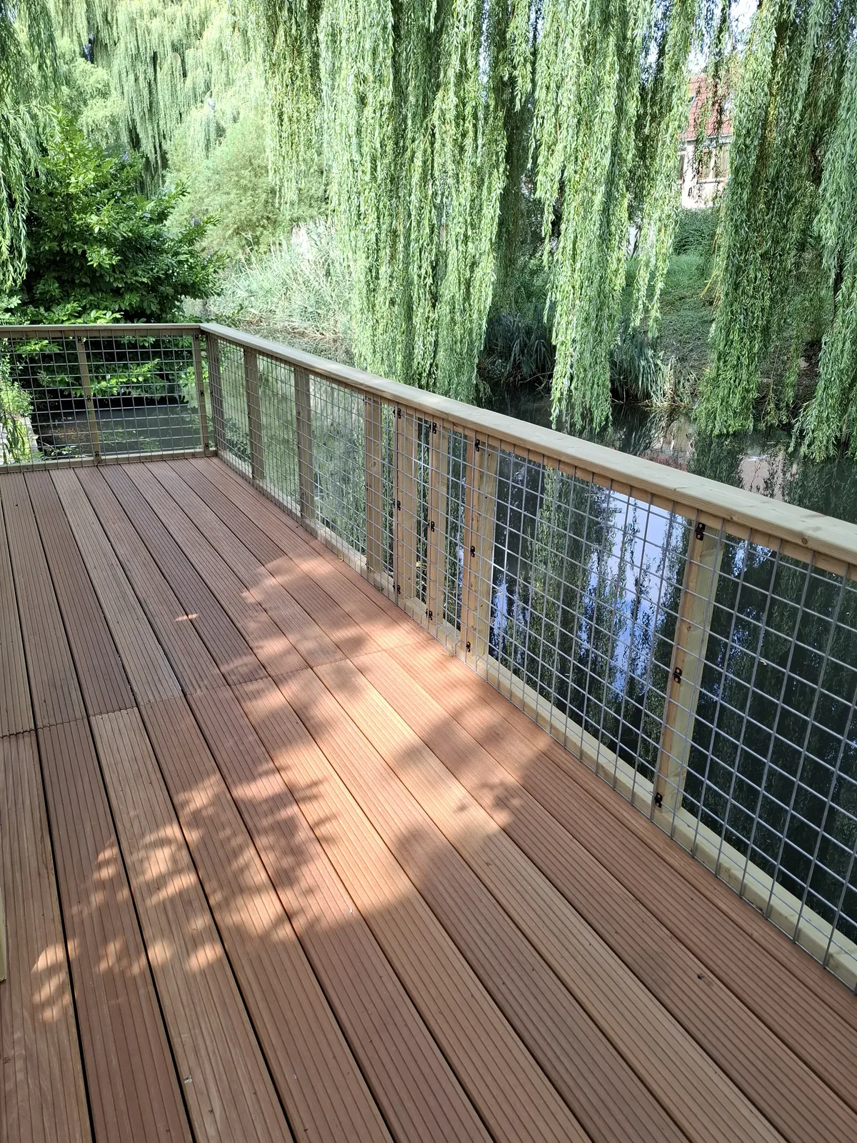 Hardhouten vlonder met balustrade van gaas aan het water
